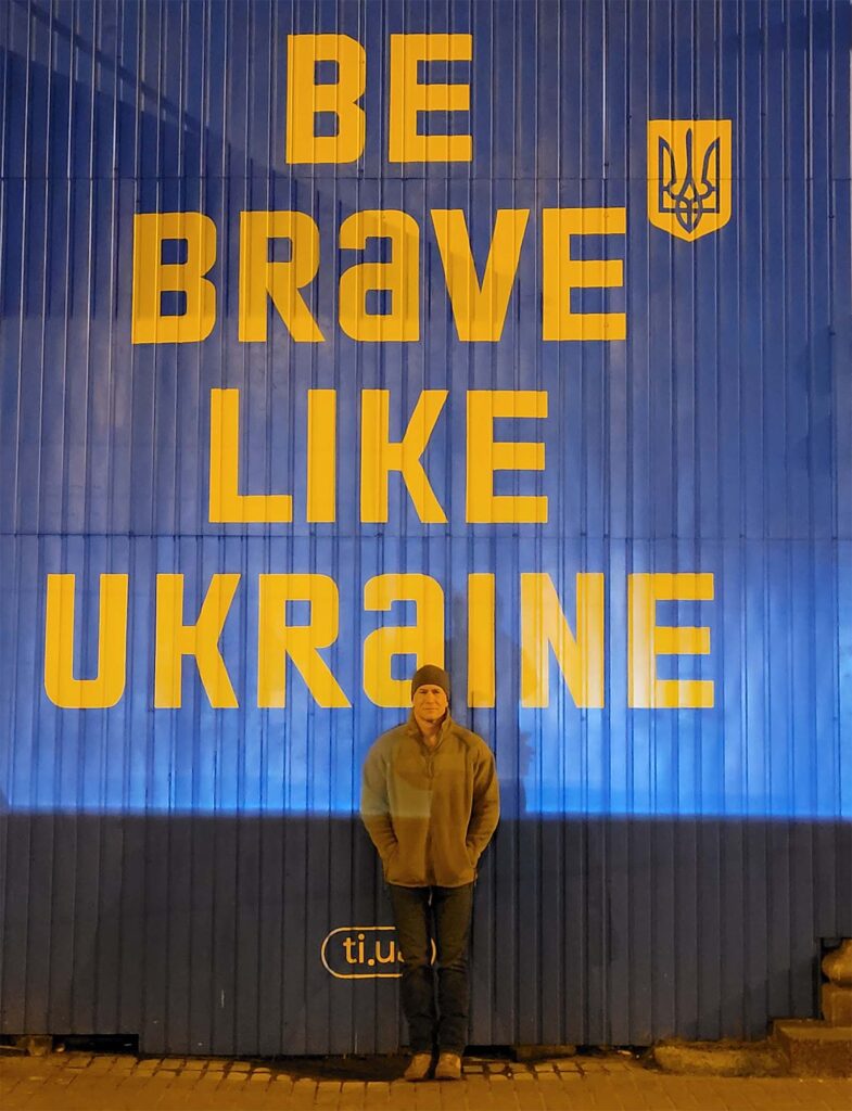 Photo of Michael in front of the sign Be Brave Like Ukraine