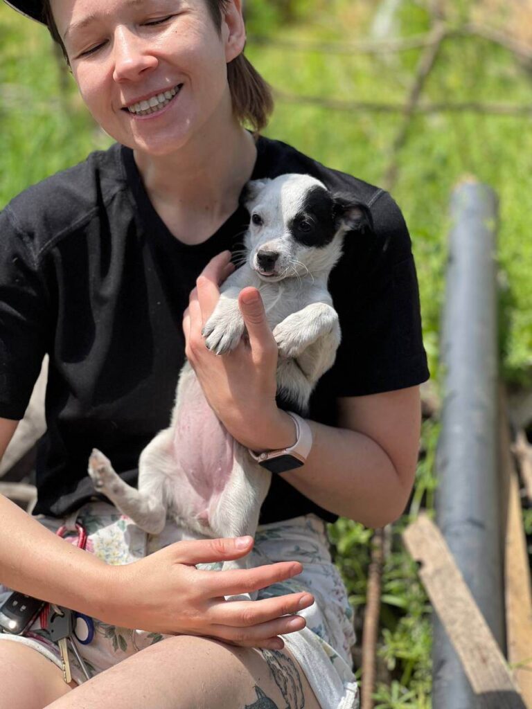 Photo of puppy and the woman taking care of it